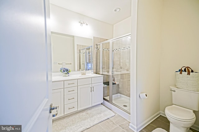 bathroom featuring walk in shower, vanity, toilet, and tile patterned flooring