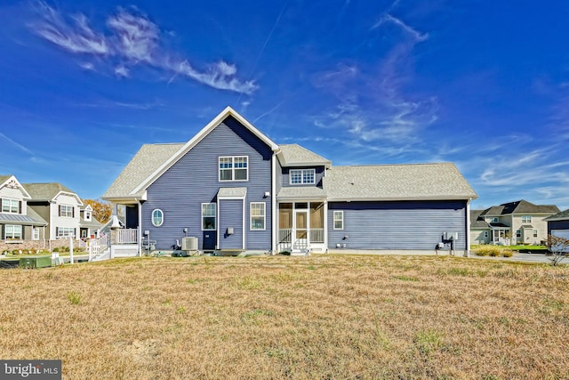 view of front of house with a front lawn and central AC