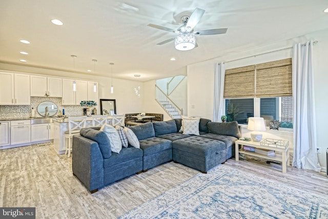 living room with ceiling fan and light wood-type flooring