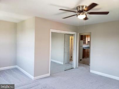 unfurnished bedroom featuring ceiling fan and light colored carpet