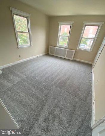 carpeted spare room featuring a healthy amount of sunlight