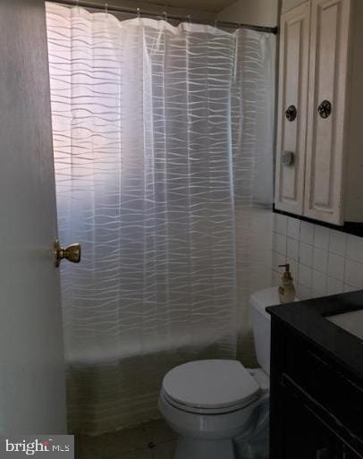 full bathroom featuring shower / bath combo, tasteful backsplash, vanity, tile walls, and toilet