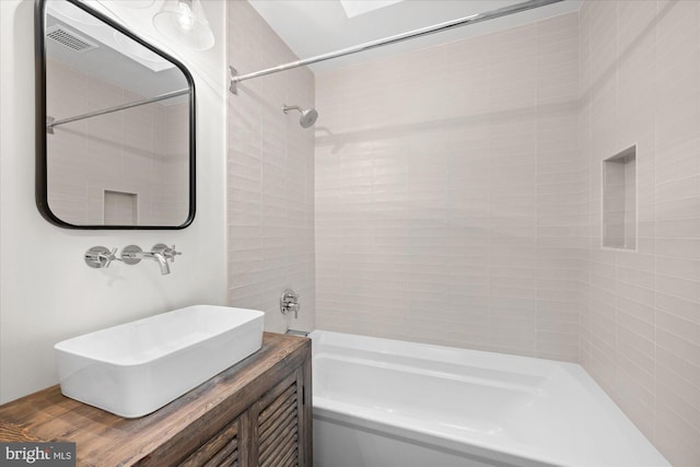 bathroom featuring sink, wood-type flooring, and tiled shower / bath