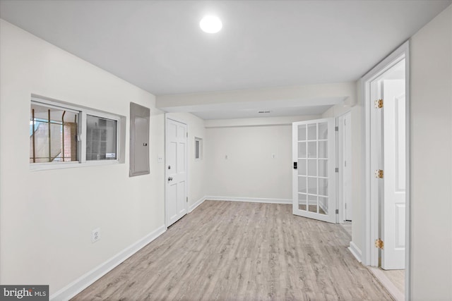 empty room featuring electric panel and light hardwood / wood-style floors