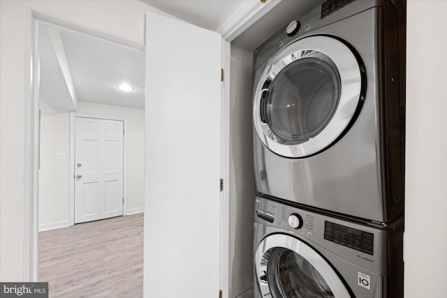 laundry room featuring light hardwood / wood-style flooring and stacked washer / drying machine