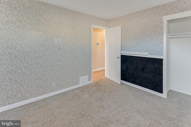 unfurnished bedroom with carpet flooring and a closet