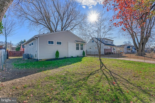 rear view of house with a lawn and central AC unit