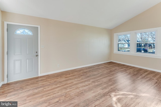 foyer entrance with light hardwood / wood-style flooring, plenty of natural light, and lofted ceiling