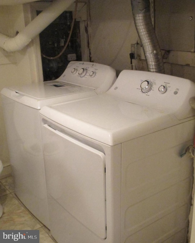 laundry room featuring light tile patterned floors and washing machine and dryer