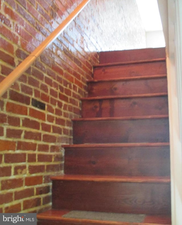 stairs featuring brick wall