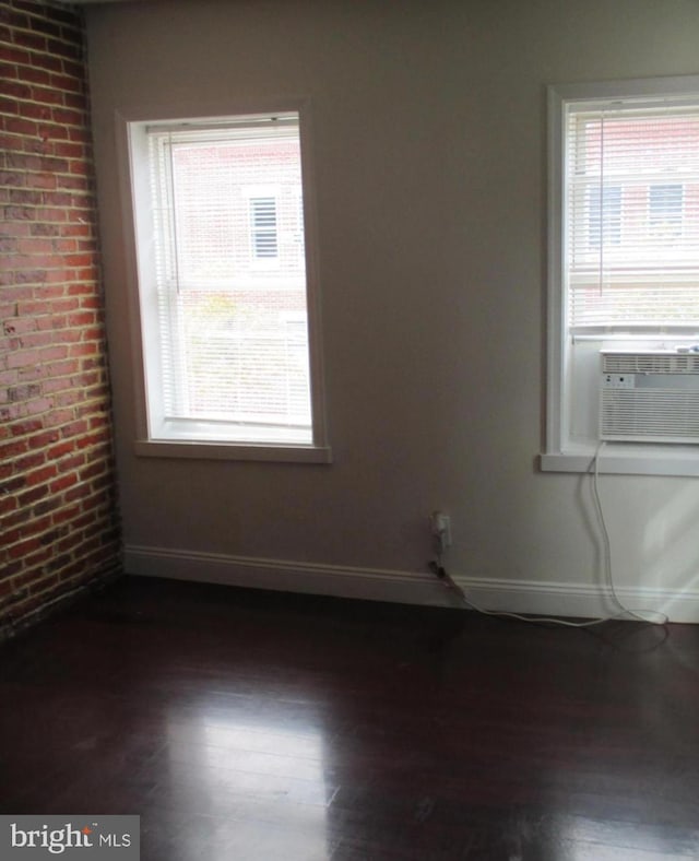 empty room with cooling unit and dark hardwood / wood-style flooring