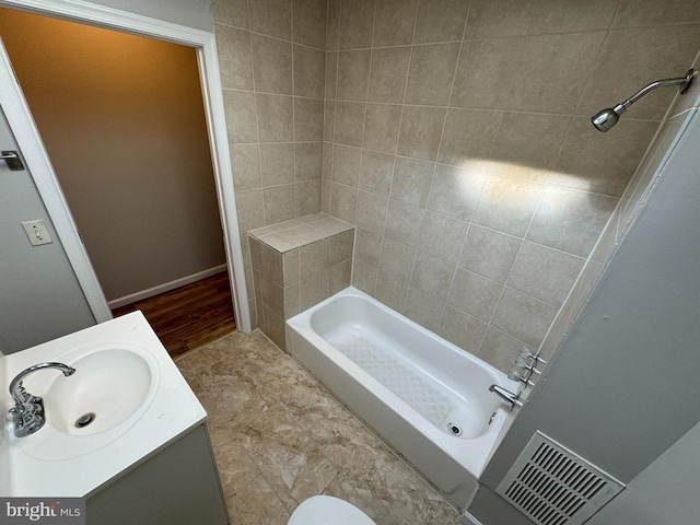 bathroom featuring tiled shower / bath and vanity