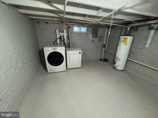 basement featuring electric panel, gas water heater, and washing machine and clothes dryer