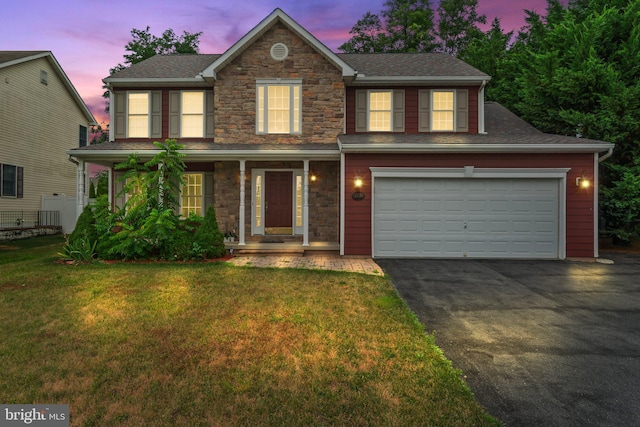 view of front of property with a garage, a porch, and a yard