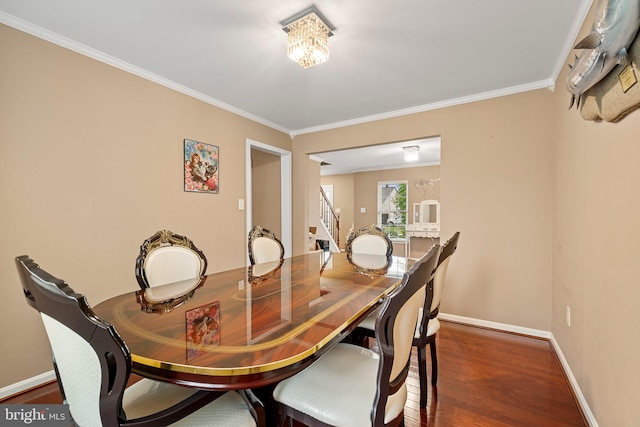 dining space with crown molding, an inviting chandelier, and dark hardwood / wood-style flooring