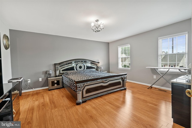 bedroom featuring hardwood / wood-style floors and a chandelier