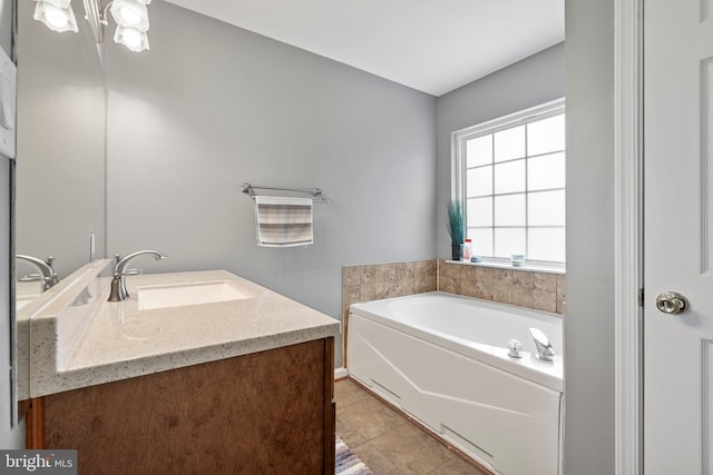 bathroom featuring tile patterned flooring, a bath, and vanity