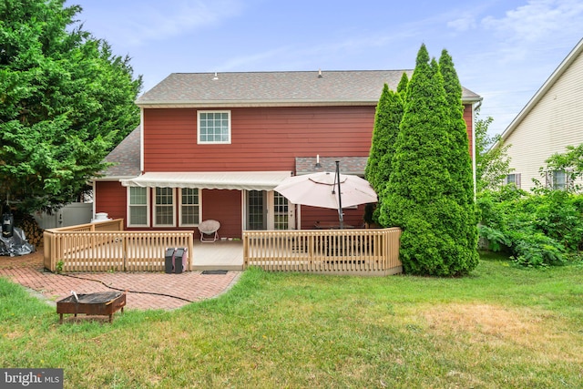 back of house featuring a deck, a patio, and a yard