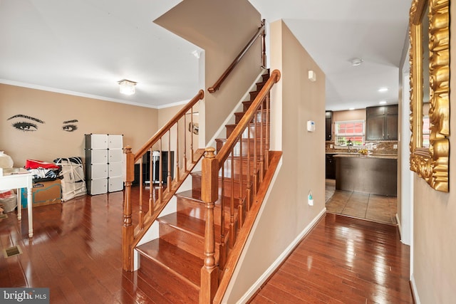 stairs featuring wood-type flooring and ornamental molding