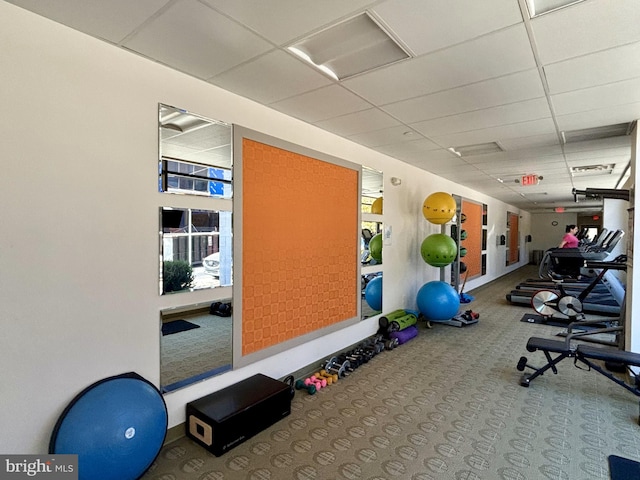 gym with a drop ceiling and carpet floors