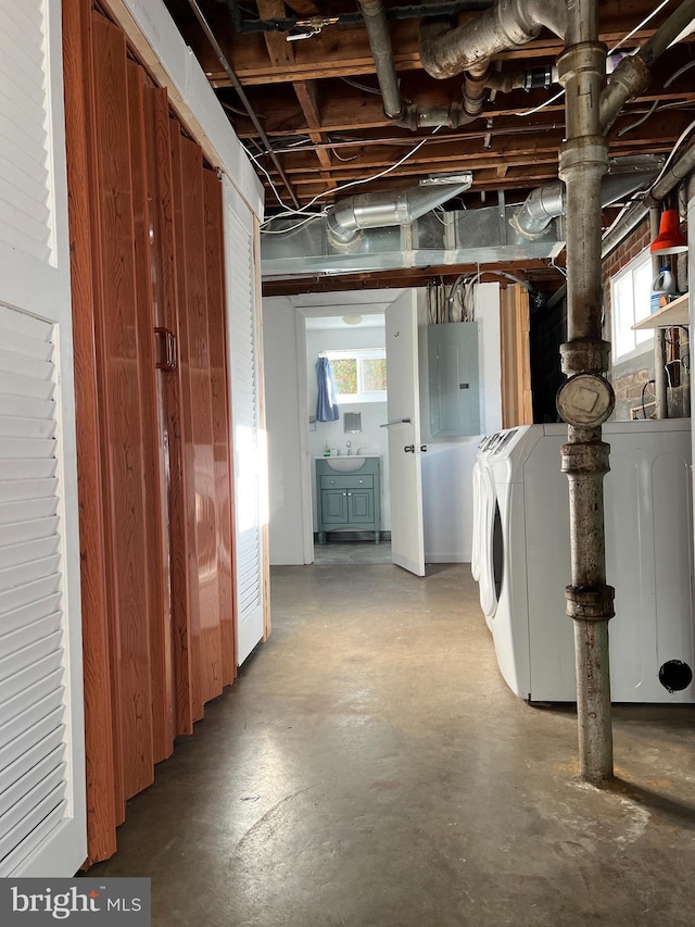 basement featuring washer and clothes dryer, electric panel, and plenty of natural light