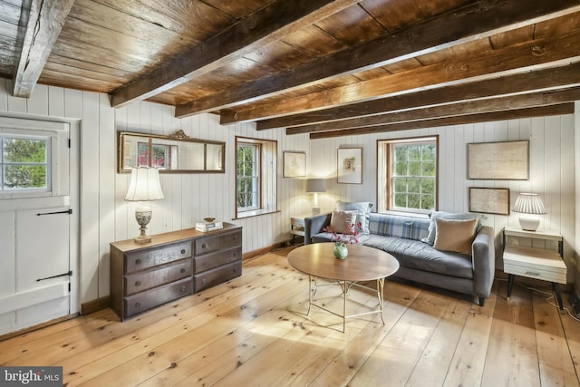 living area with wooden ceiling, beamed ceiling, wood walls, and light wood-type flooring