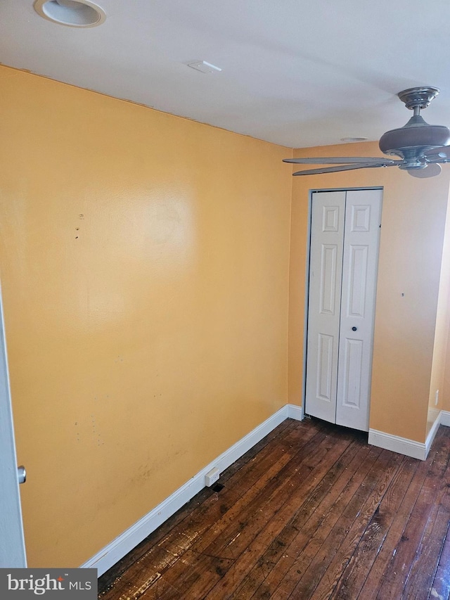 unfurnished bedroom with dark wood-type flooring and a closet