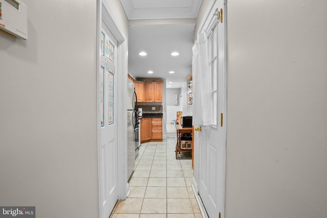 kitchen featuring light tile patterned flooring, stainless steel fridge, backsplash, and crown molding