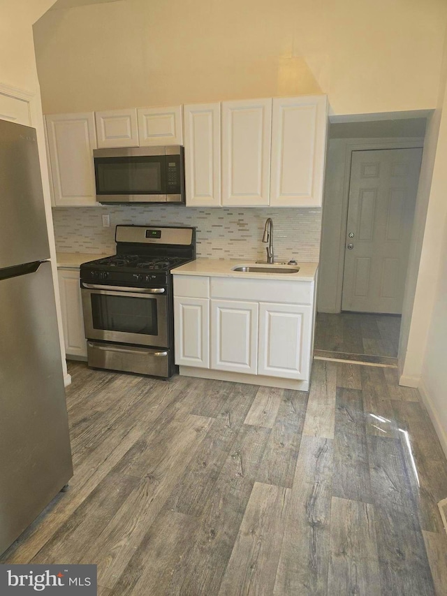 kitchen featuring stainless steel appliances, dark hardwood / wood-style floors, white cabinets, and sink