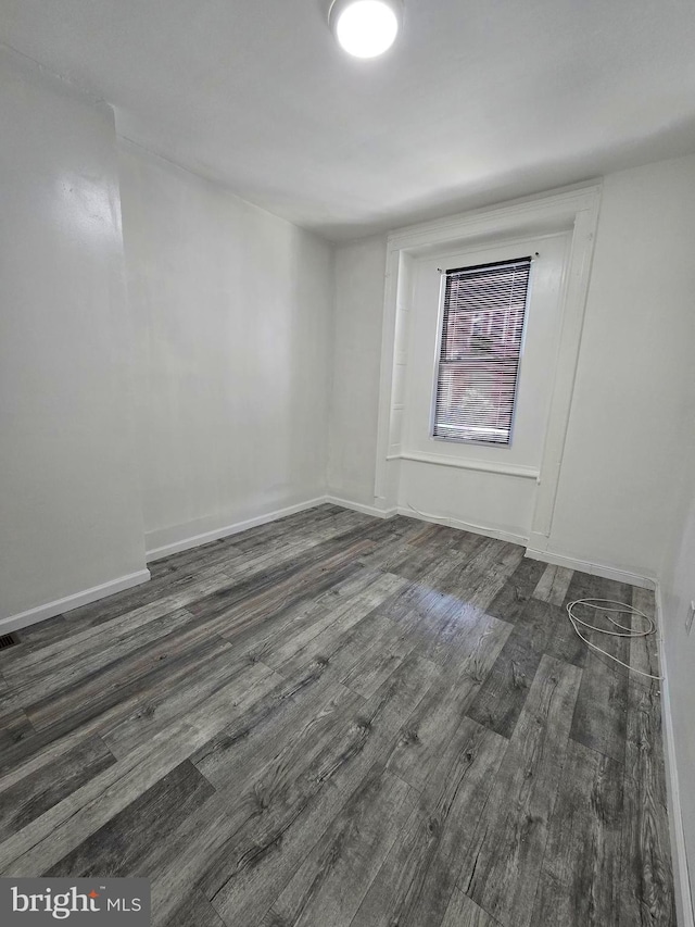 unfurnished room with dark wood-type flooring