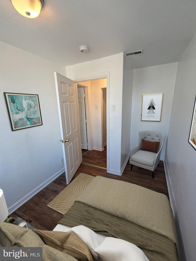 bedroom with dark hardwood / wood-style flooring