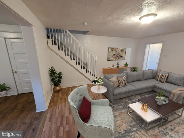 living room featuring a textured ceiling and dark hardwood / wood-style flooring