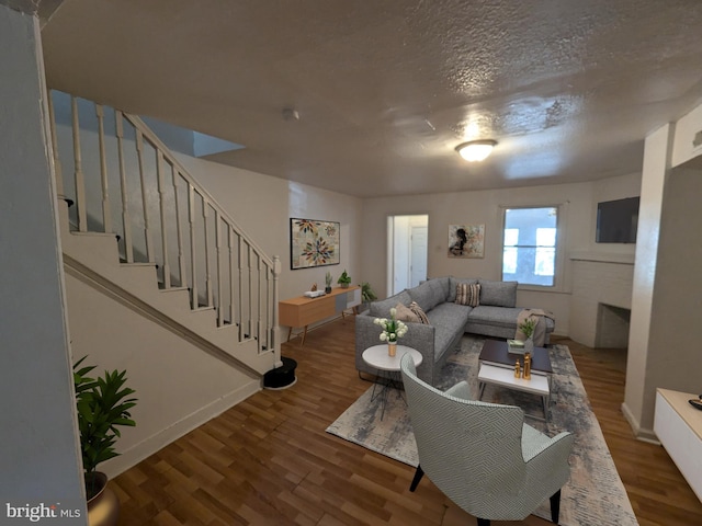 living room with wood-type flooring and a textured ceiling