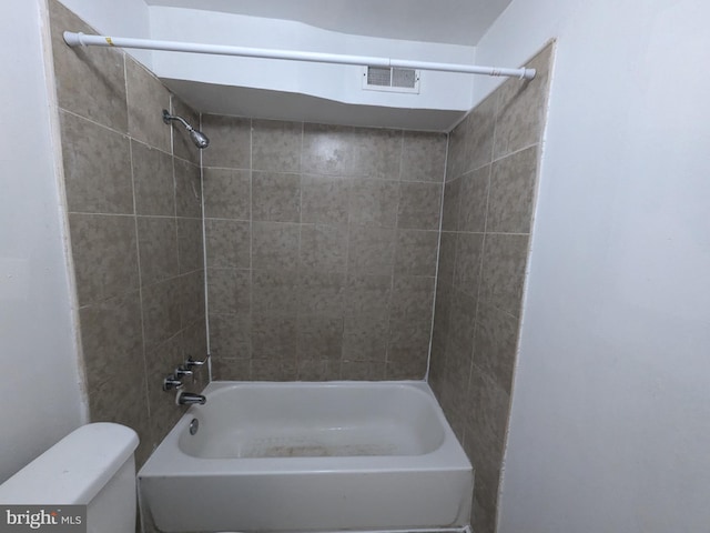 bathroom featuring tiled shower / bath combo and toilet