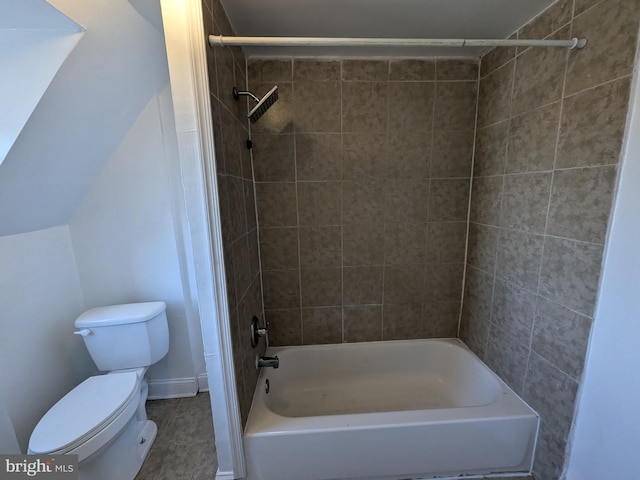 bathroom with tiled shower / bath combo and toilet