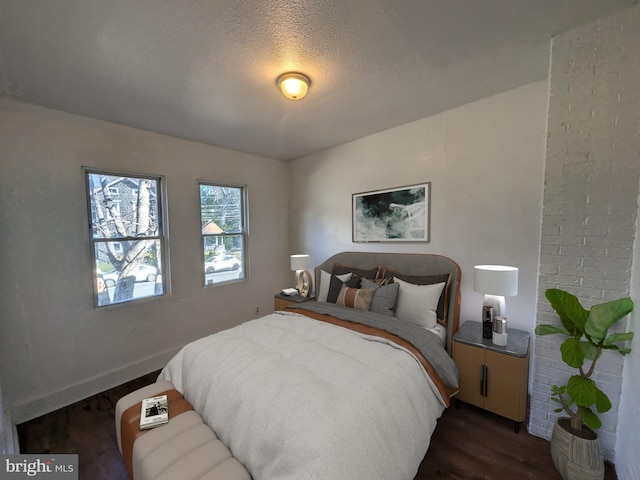 bedroom with dark wood-type flooring and a textured ceiling