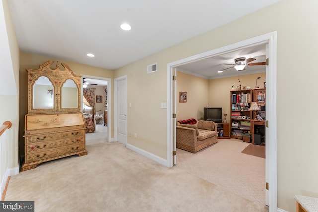 living area with ceiling fan, carpet flooring, and crown molding