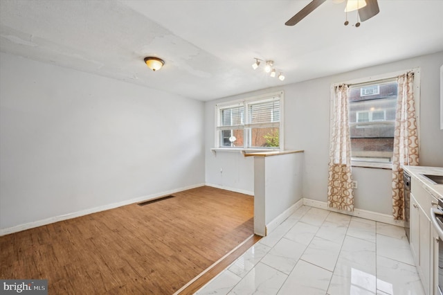 kitchen with ceiling fan, light hardwood / wood-style floors, and white cabinets