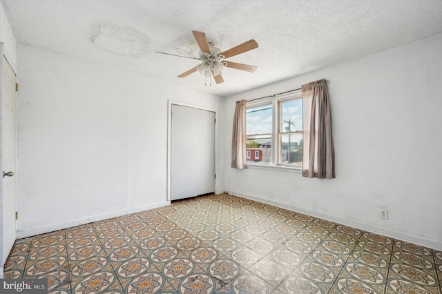 unfurnished bedroom with ceiling fan, a textured ceiling, and a closet