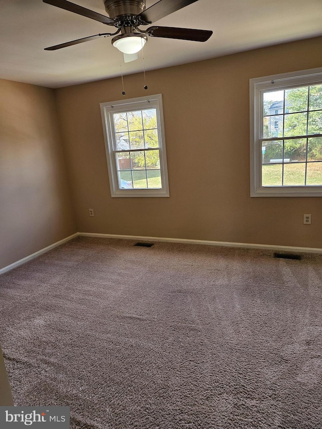 carpeted spare room featuring ceiling fan