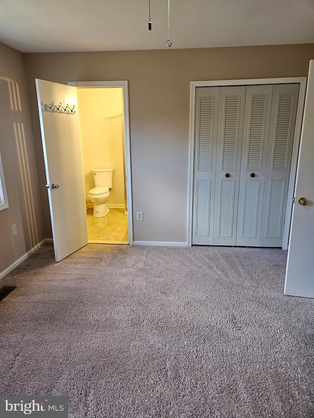 unfurnished bedroom featuring carpet floors, connected bathroom, and a closet