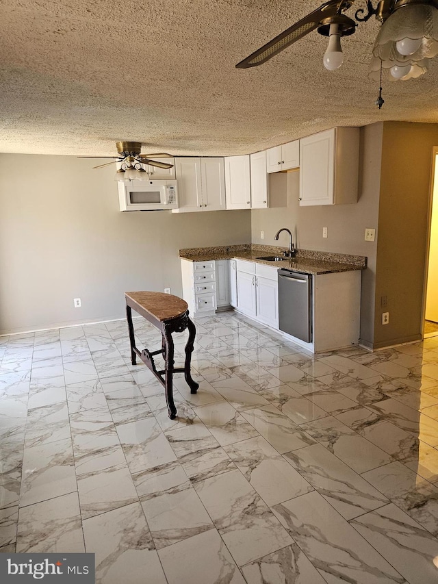 kitchen with a textured ceiling, ceiling fan, sink, dishwasher, and white cabinetry