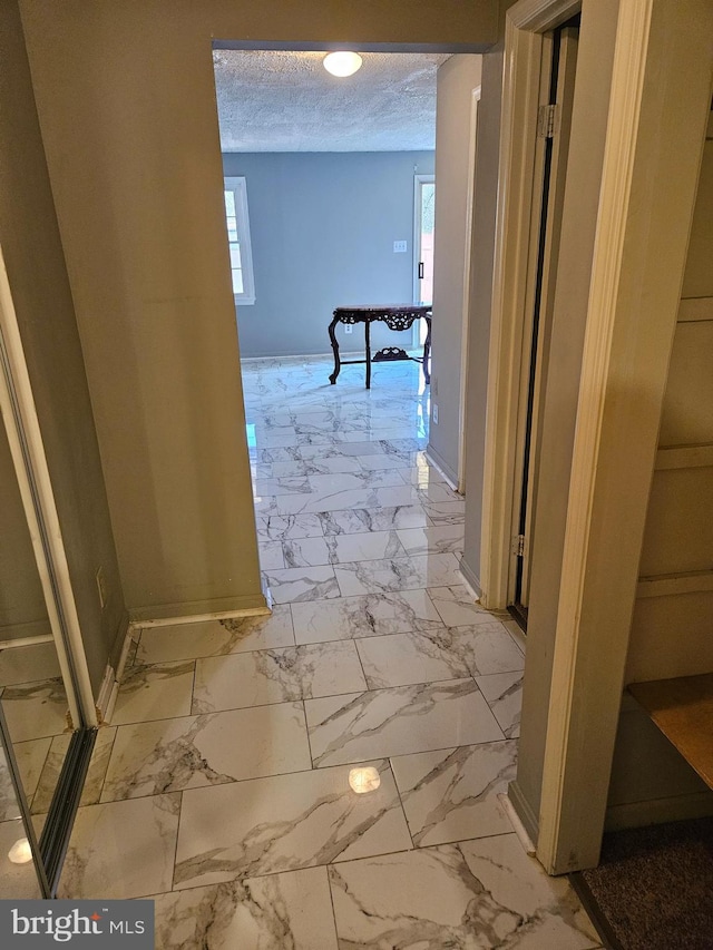 hallway featuring plenty of natural light and a textured ceiling