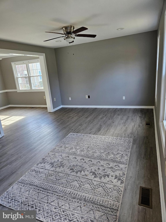 spare room with ceiling fan and dark hardwood / wood-style flooring