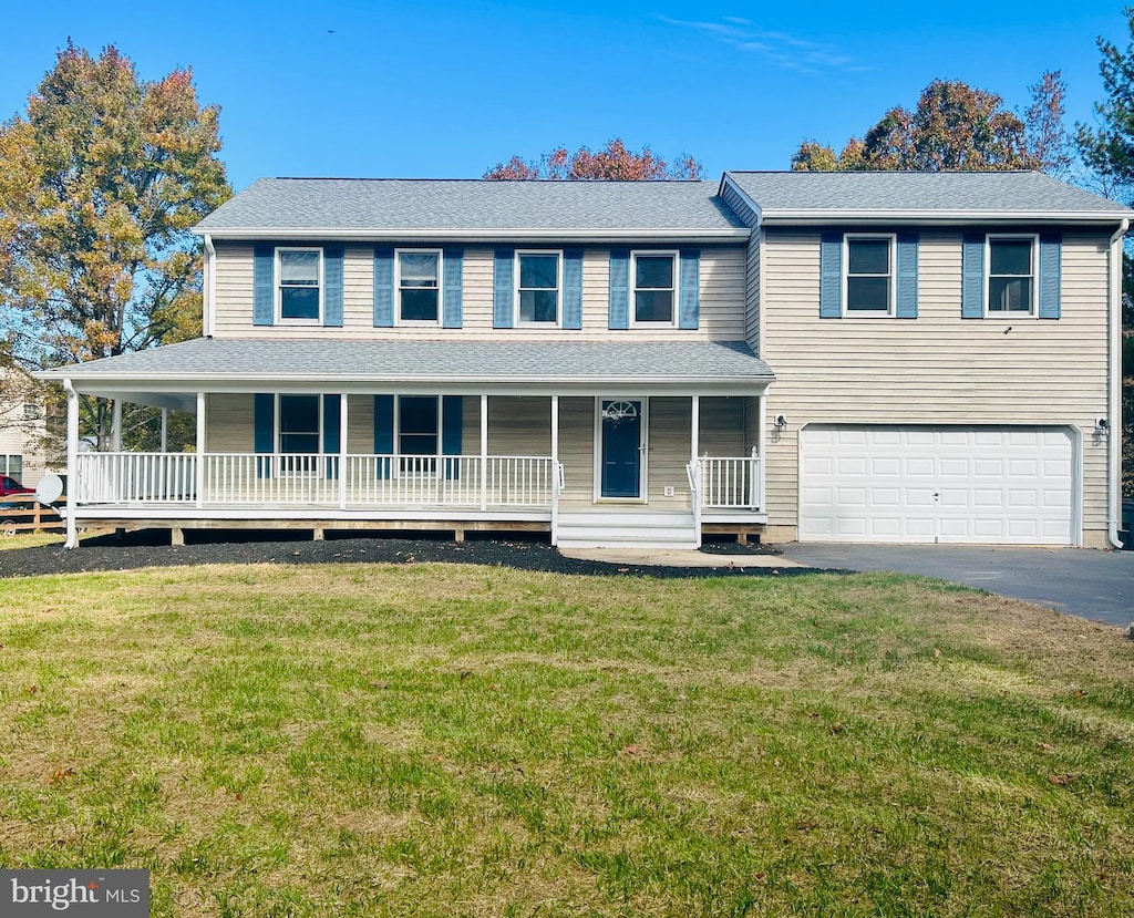 view of front of home featuring a front lawn, a porch, and a garage