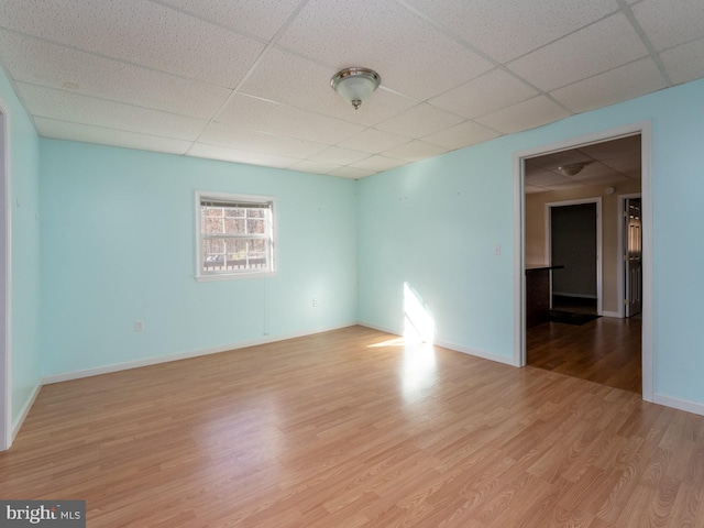 spare room with light wood-type flooring and a drop ceiling