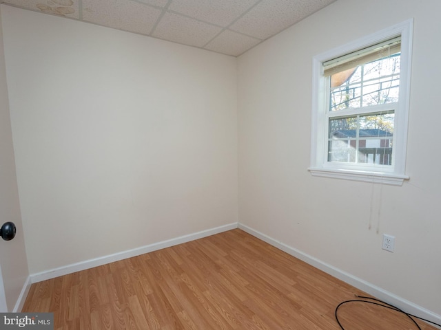 unfurnished room with a paneled ceiling and light hardwood / wood-style flooring