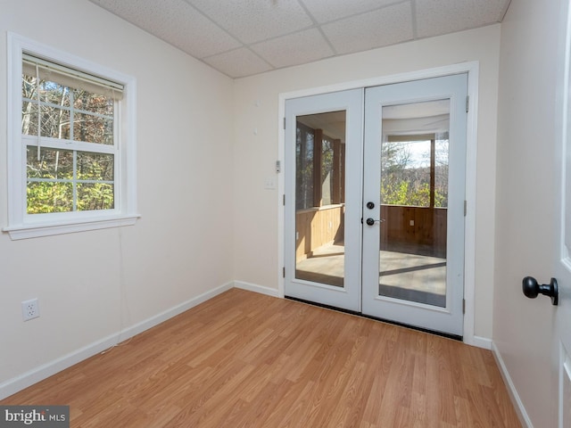 doorway to outside with french doors, light hardwood / wood-style flooring, and a paneled ceiling