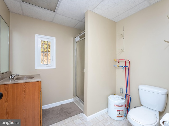 bathroom featuring walk in shower, vanity, toilet, and a paneled ceiling