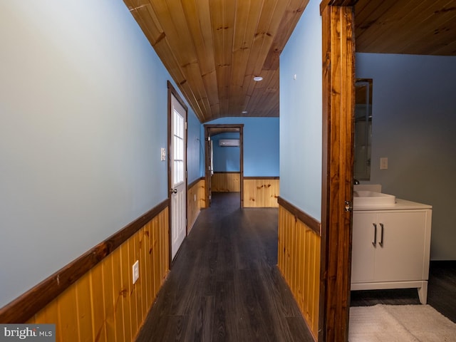 hallway with wooden ceiling, sink, lofted ceiling, wooden walls, and dark hardwood / wood-style flooring